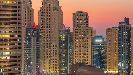 Dubai marina and JBR towers panorama day to night timelapse lights turn on.