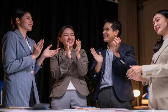 A group of people are clapping and smiling
