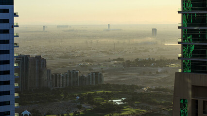Early morning during sunrise aerial view from skyscraper with foggy weather near Dubai Marina