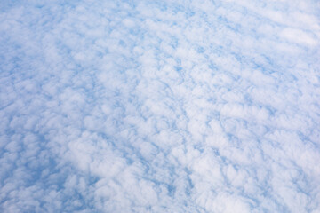 Textured blanket of puffy clouds, seen from above. Panoramic view of the sky, filled with a multitude of fluffy clouds