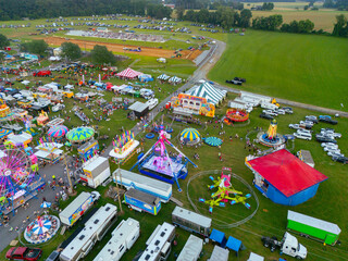 Aerial drone view of a county fair, dirt track, and a parking lot with cars. Amusement rides. Children. Fun. 