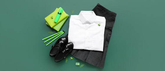 Different stationery and stylish school uniform on green chalkboard © Pixel-Shot