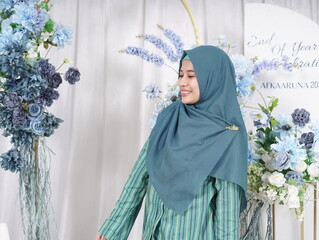 An hijabi Muslimah woman wearing traditional clothes posing in the studio photo looks like walking...