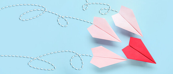 Colorful origami paper planes on blue background