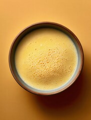 Mango pomelo sago dessert served in frosted bowl against matte mango yellow background
