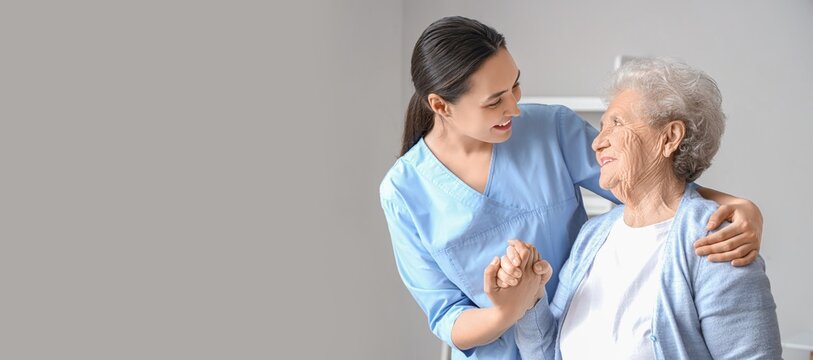 Senior woman with physical therapist hugging at home. Banner for design