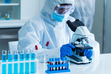 Scientist man look into Microscope research in science laboratory. Asian scientist look at...