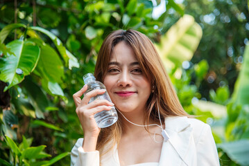 Young Woman Drinking Water bottle outdoor park traveler. Asian female drinking water bottle healthy...
