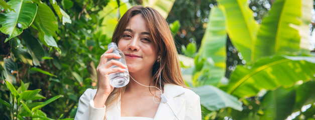 Banner Woman Drinking Water bottle outdoor park traveler. Asian female drink water bottle healthy...