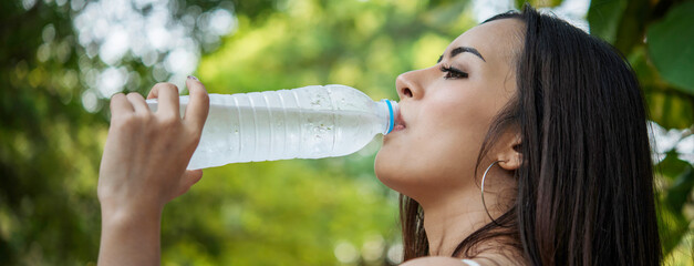 Banner Woman Drinking Water bottle outdoor park traveler. Asian female drink water bottle healthy...