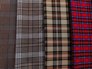 several checkered fabrics in different shades and patterns are arranged neatly, showcasing options...