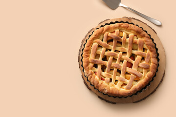 Wooden tray with tasty homemade apple pie and spatula on beige background