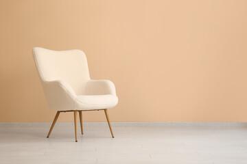 Comfortable armchair near beige wall