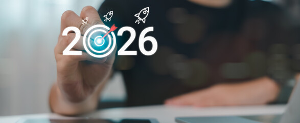 Hand writing 2026 with target and rocket icons, symbolizing business goals, new year planning, strategic vision, success roadmap, and future achievement.