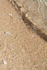 ガラスのように透明な波が打ち寄せる穏やかな波打ち際