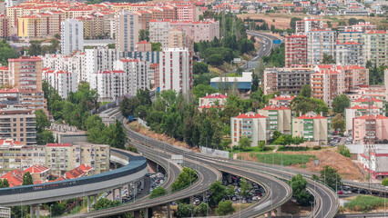 Aerial top view of highway multilevel junction road in urban populated area timelapse.
