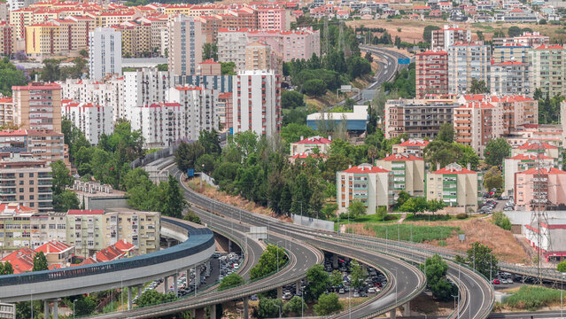Aerial top view of highway multilevel junction road in urban populated area timelapse.