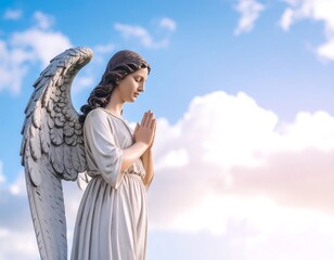 Fototapeta premium Angel statue praying against a sky
