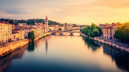 Fototapeta premium Historic city architecture lines a river with a bridge at sunset showing buildings and trees