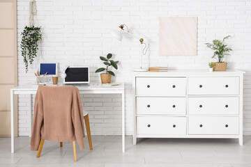 Interior of office with workplace, commode and plants