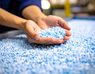 手のひらに広げられた青色のプラスチックペレット