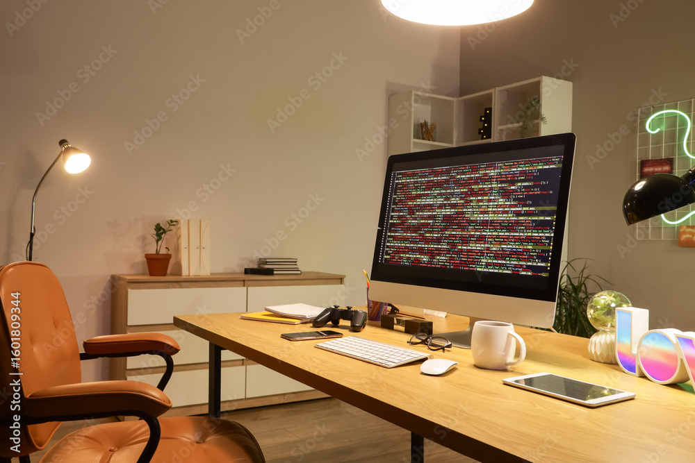 Wall mural programmer's desk with computer and glowing lamps in office at night