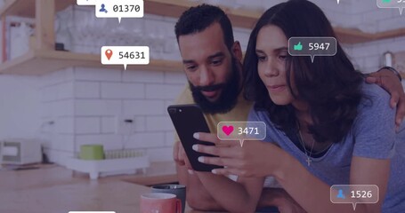 Couple tapping smartphone and watching social media icons multiplying showing engagement growth - Powered by Adobe