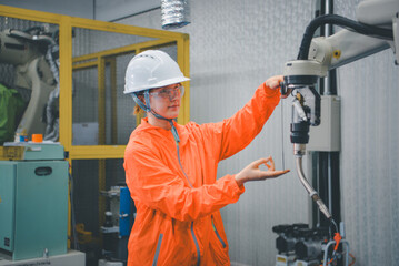 Robotic machine enginee is testing the operation of the robot arm manufacturing machine