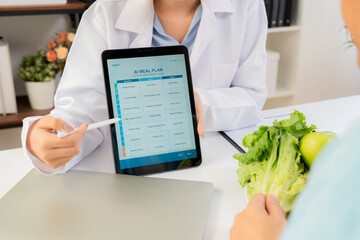Asian nutritionist using tablet to explaining personalized meal plan with AI to patient during...