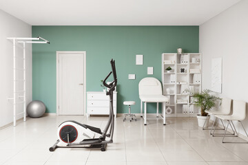 Interior of physiotherapist's office with couch and exercising bike