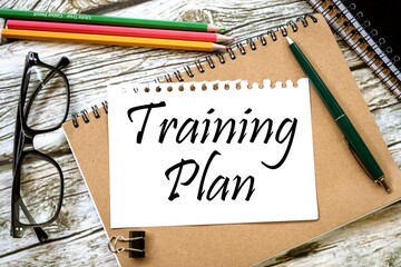 Training Plan. on a torn page from a notebook in a brown notebook. view from above.