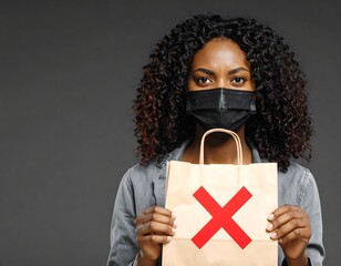 Woman wearing paper bag mask with bold red X sign, clenching fists