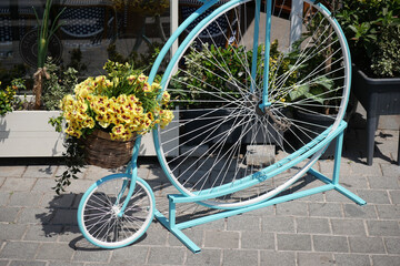 Decorative bicycle with flowers displayed in a garden