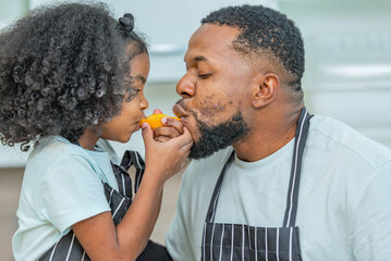 african afro hair black kid Cute taste oranges citrus sour flavour on lips mouth with daddy in...