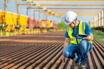Asian Engineer Kneeling: Professional Inspection of Railway Maintenance Worker: Technician Checking...