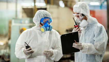 Male inspector team investigate danger chemical gas leak spill with safety face mask PPE suit in...