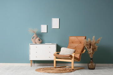 Interior of living room with armchair, pampas grass and commode