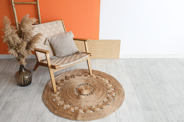 Interior of stylish living room with wooden armchair, pampas grass and ladder