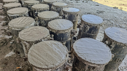 Fresh concrete samples inside cylindrical molds at a construction site, used for strength testing and quality control in civil engineering.