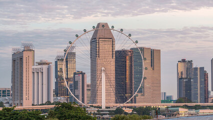 Skyline of Singapore with famous Singapore Ferries Wheel night to day timelapse