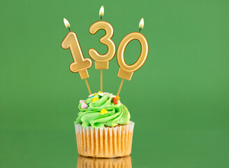 Number 130 birthday candle - Cupcake on a green background