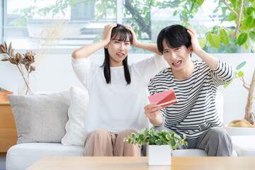 リビングで通帳を見る若い夫婦