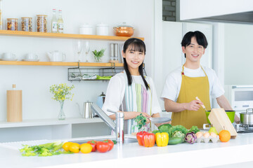 キッチンで一緒に料理をする若い夫婦