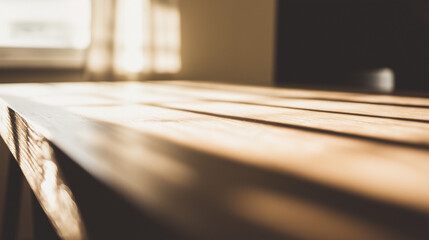 Minimalist wooden desk bathed in warm morning sunlight with a clean, shallow focus.