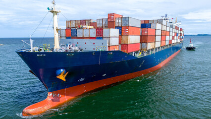 Fototapeta premium Aerial of cargo ship carrying container for export cargo from cargo yard port to other ocean concept smart freight shipping ship front view