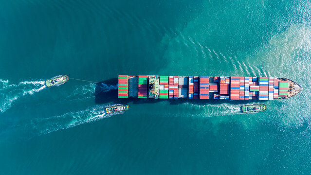 Aerial of cargo ship carrying container for export cargo from cargo yard port to other ocean concept smart freight shipping ship top view