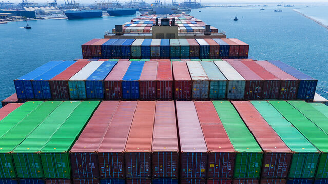 Aerial of cargo ship carrying container  for export cargo from cargo yard port to other ocean concept smart freight shipping ship stern view