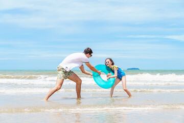 Family Vacation on Summer Beach, Father and Daughter Playing with Inflatable Swim Ring in Sea, Outdoor Fun and Joyful Bonding