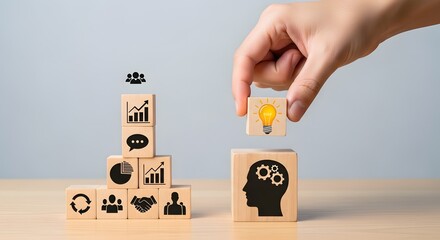 Hand placing lightbulb block on head with gears block near other blocks with business icons