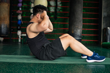 Fitness enthusiast performs abdominal exercises in a gym environment focusing on strength and...